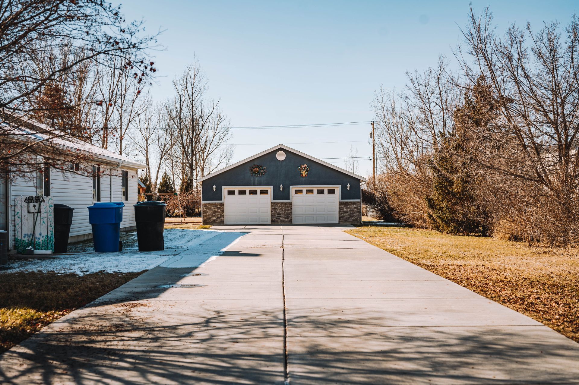 Spacious suburban driveway with house and garage in a peaceful neighborhood setting.